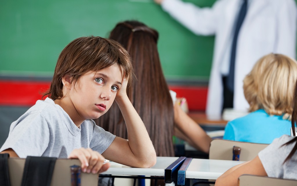 young boy in classroom looking frustrated